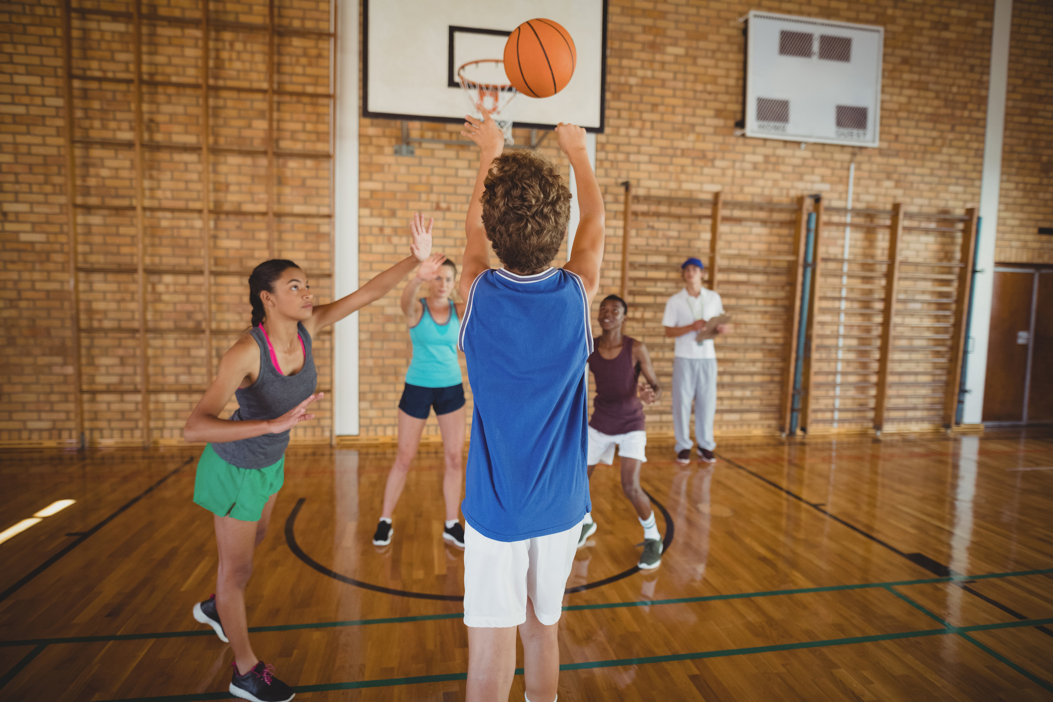 High school kids playing basketball in a gym